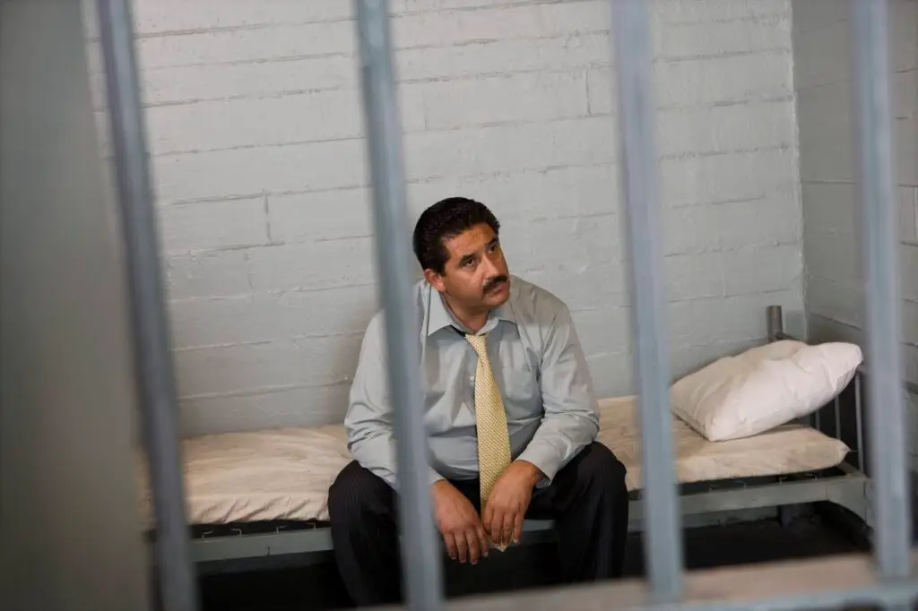 man sitting in a jail cell