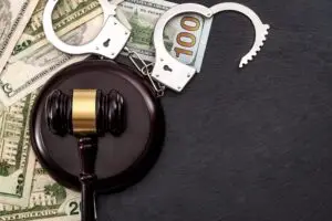 gavel, cash, and handcuffs on a table