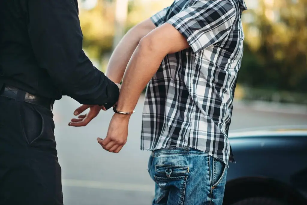 man being arrested hands behind his back